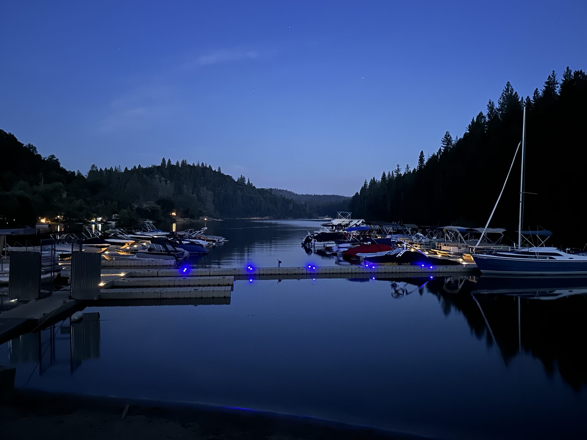 Marina at twilight with blue LED dock lights reflected on the lake